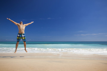 Fototapeta na wymiar Man jumping on the beach