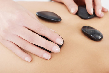Close up on female's back having stone massage.
