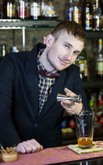 young man working as a bartender in a nightclub bar