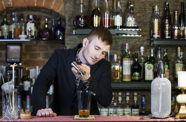 young man working as a bartender in a nightclub bar