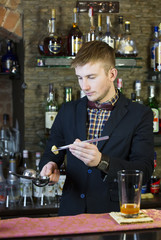 young man working as a bartender in a nightclub bar