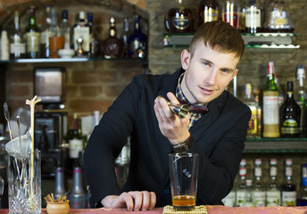 young man working as a bartender in a nightclub bar