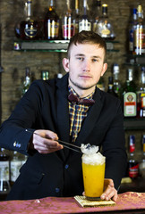 young man working as a bartender in a nightclub bar