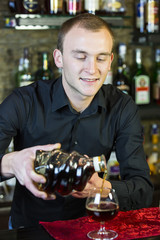 young man working as a bartender in a nightclub bar
