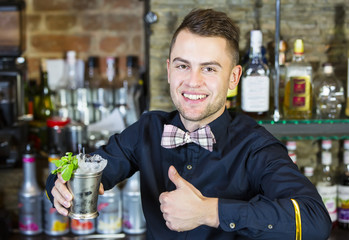 young man working as a bartender in a nightclub bar