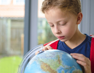 Boy studying map on a globe