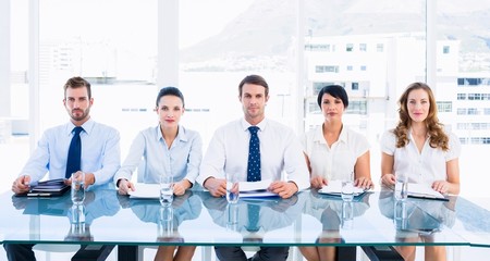 Fototapeta na wymiar Smartly dressed executives sitting in row at desk