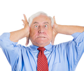 Stressed old man covering his ears from loud noise, headache