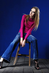 fashion model in fashion clothes sitting wooden chair