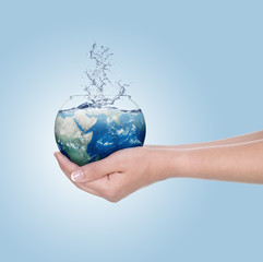 Globe in human hand against blue sky