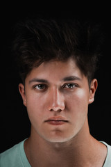 Fototapeta premium Close-up portrait of attractive young man on black background