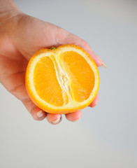 Half of orange in hand