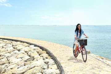 Obraz na płótnie Canvas woman having fun riding bicycle at the beach