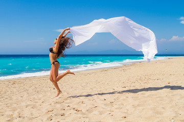 Beautiful Girl With White fabric on The Beach.