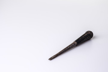 Old black screwdriver on white background