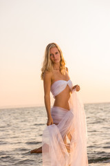 Fototapeta na wymiar woman wrapped in wedding veil on the beach