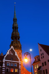 Obraz premium alte Häusere und Kirchturm in Riga zur blauen Stunde