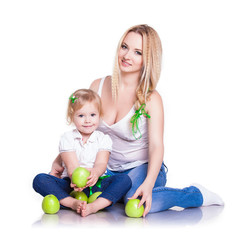 Fototapeta na wymiar portrait of young mother and little daughter with apples