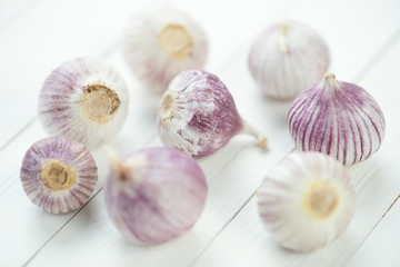 Chinese garlic bulbs over white wooden background, close-up