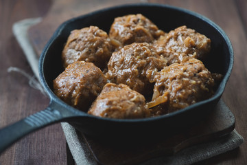 Meatballs with gravy in cast-iron pan, close-up