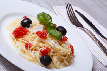spaghetti with tomatoes, olives, basil and parmesan cheese