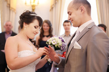 groom wears the ring bride