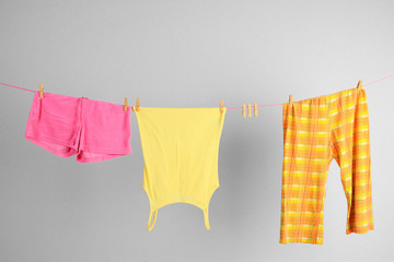 Laundry line with clothes on wall background