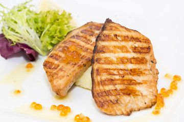 Grilled salmon fillet with vegetables and caviar