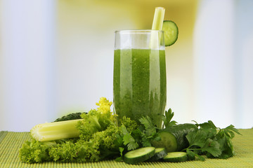 Glass of green vegetable juice and vegetables
