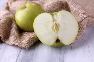 Apples and sackcloth on  on wooden background
