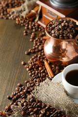 Cup of coffee, pot and grinder on wooden background