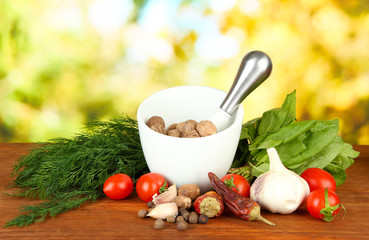 Composition of mortar,spices, tomatoes and  green herbs,