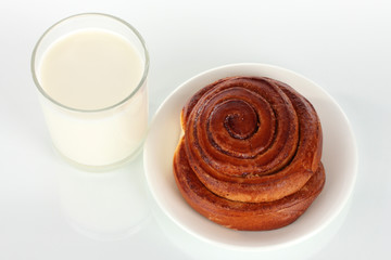 Bread roll and glass of milk isolated on white