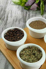 Assortment of spices in  white  bowls, on wooden background