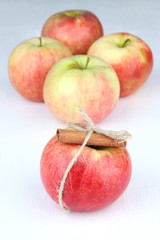 Ripe apples with with cinnamon sticks isolated on white