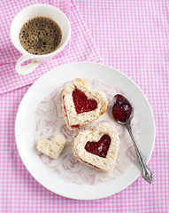 Heart shape sandwich with strawberry jam on a plate
