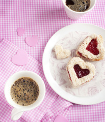 Heart shape sandwich with strawberry jam on a plate