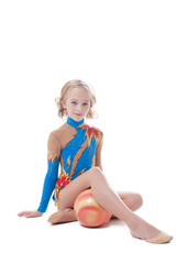 Obraz na płótnie Canvas Stately little gymnast sitting in studio with ball