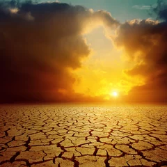 Photo sur Plexiglas Ciel orange cloudy sunset over cracked desert