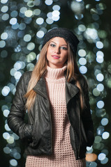 Fashionable lady wearing cap and black jacket outdoor in xmas