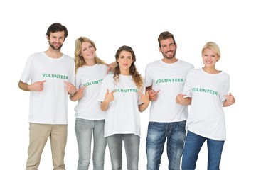Group portrait of happy volunteers pointing to themselves