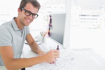 Side view of a smiling young man using compass