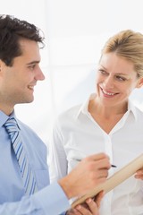 Fototapeta premium Happy business team working from clipboard together