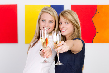 two women clink glasses