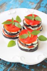 snack from tomato and an eggplant with sauce and greens