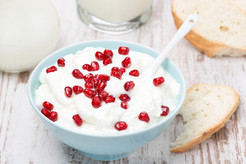 homemade yogurt with pomegranate, milk and bread, top view
