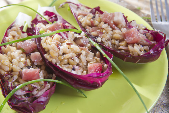Boat of brown rice with red radicchio and speck