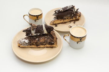 Chocolate cakes with cups of coffee on white background