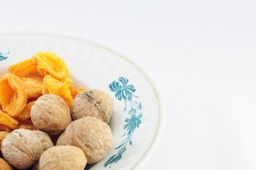 Dried fruits and nuts on the plate on the left down