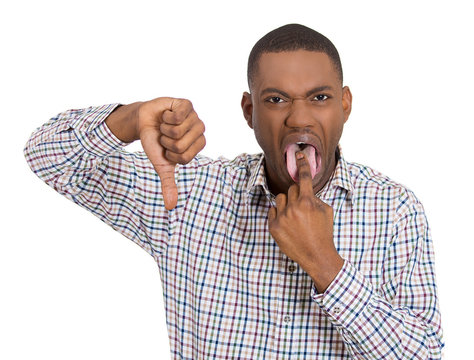Unhappy man sticking out his tongue, giving thumbs down